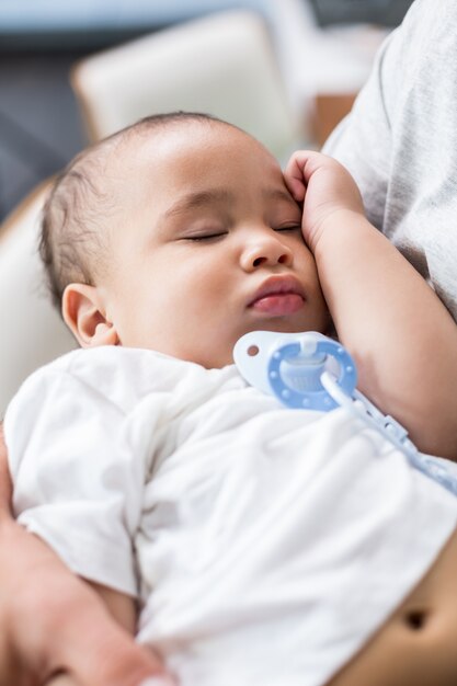 Père portant un bébé endormi à la maison