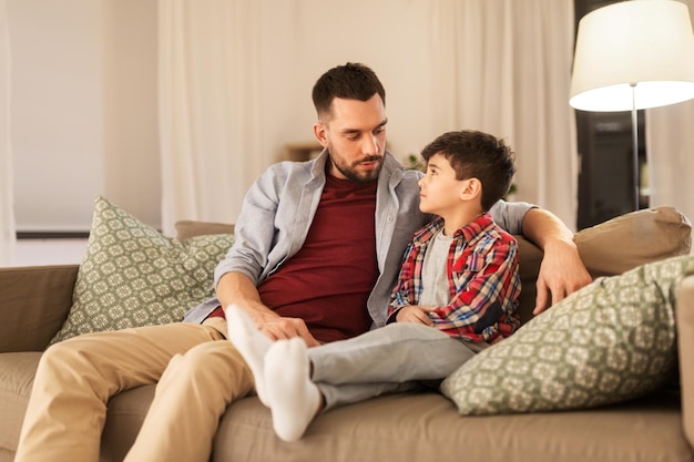 un père qui parle à son petit fils triste à la maison