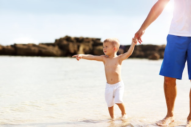 père s'amusant sur la plage avec son petit fils