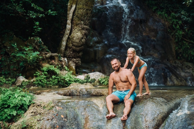 Père avec sa fille près d'une cascade. Nature itinérante près d'une belle cascade