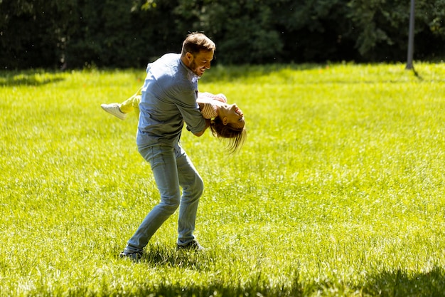 Père avec sa fille s'amusant sur l'herbe au parc