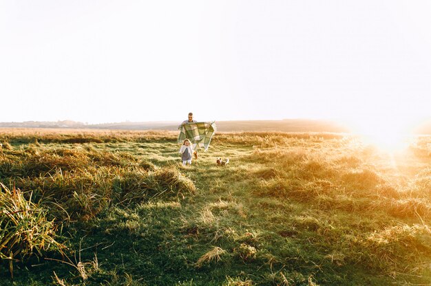 Père et sa fille s&#39;amusent et courent au coucher du soleil