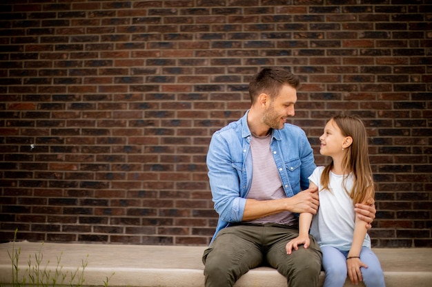 Père et sa fille s'amusent devant la porte de la maison