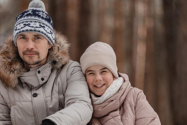 Père se promène avec sa petite fille dans la forêt d'hiver Heureux père de famille et enfant fille dans la nature Concept de la fête des pères