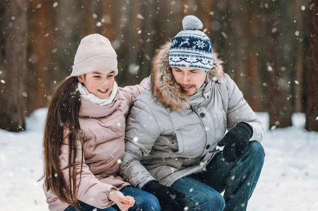 Père se promène avec sa petite fille dans la forêt d'hiver Heureux père de famille et enfant fille dans la nature Concept de la fête des pères