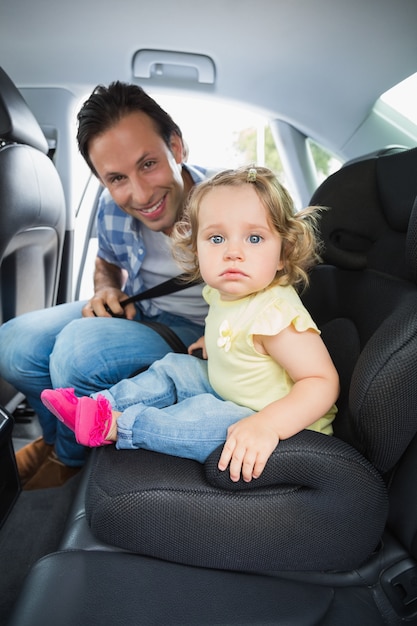 Père sécurisant son bébé dans le siège d&#39;auto