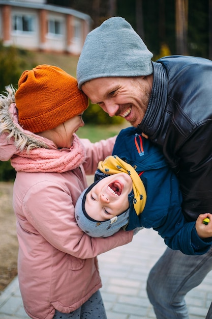 Photo un père et ses deux enfants se promènent dans la nature en automne, passent du temps ensemble, s'amusent.