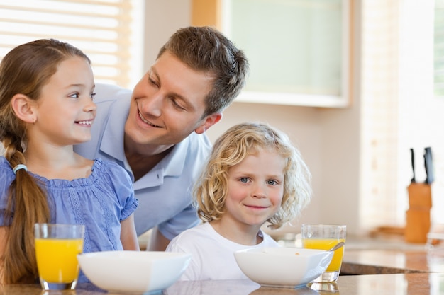 Père avec ses enfants derrière le comptoir de la cuisine