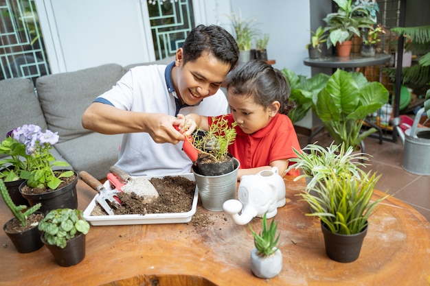 Père et ses filles plantent des plantes en pot