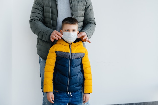 Un père avec son enfant se tient dans un masque pendant la quarantaine. Pandémie, coronavirus.