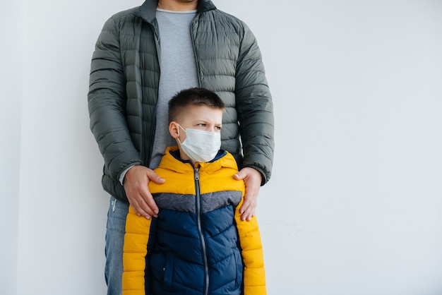 Un père avec son enfant se tient dans un masque pendant la quarantaine