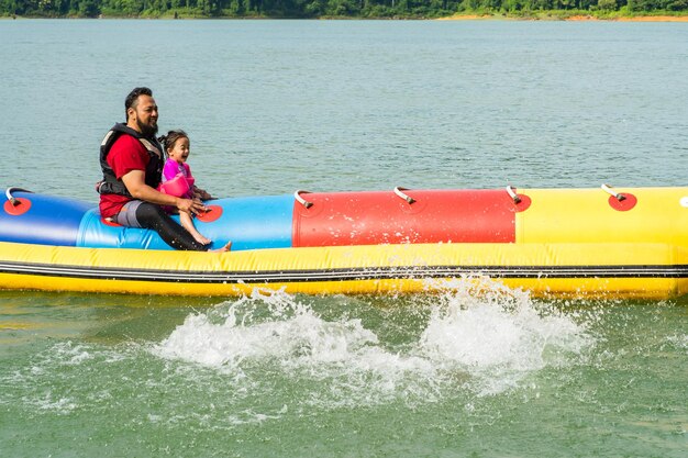 Photo un père et son fils assis sur un bateau.