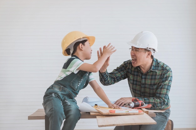 Père et son fils avec des casques high fiving