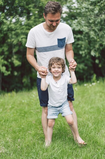 Père et son fils jouant et étreignant à l'extérieur