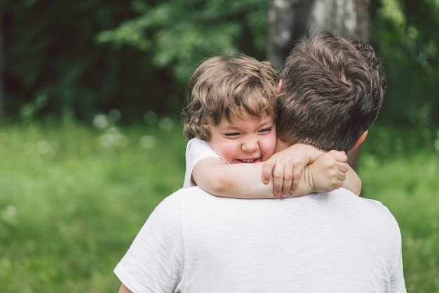 Père et son fils jouant et étreignant à l'extérieur