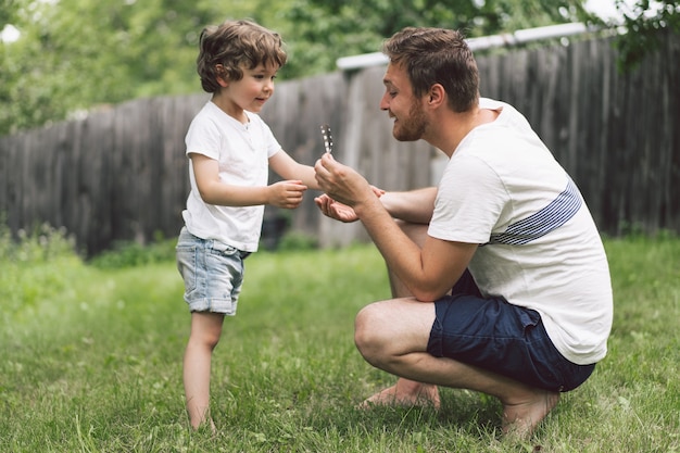 Père et son fils jouant et étreignant à l'extérieur