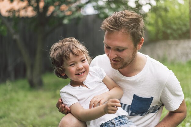 Père et son fils jouant et étreignant à l'extérieur