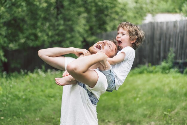 Père et son fils jouant et étreignant à l'extérieur