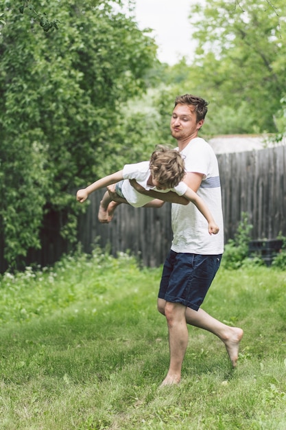 Photo père et son fils jouant et étreignant à l'extérieur