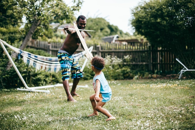 Un père et son fils jouent dans le jardin.