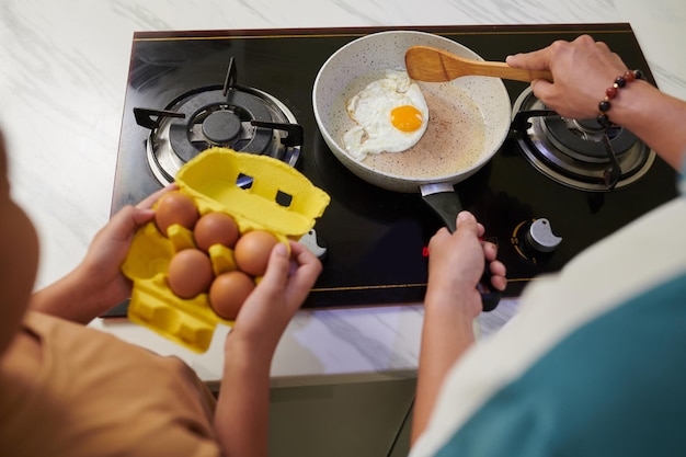 Un père et son fils préparent le petit déjeuner.