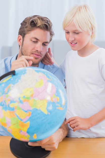 Père et son fils en regardant le globe