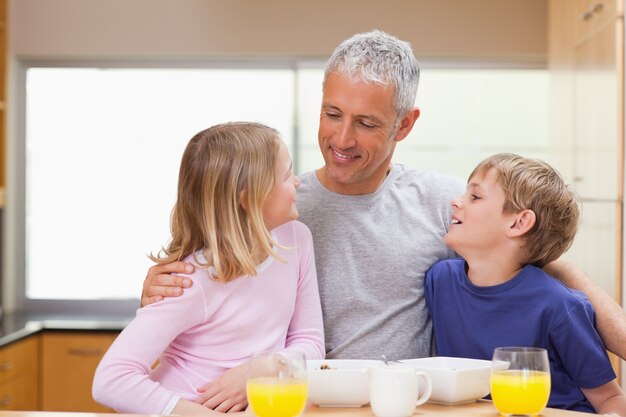 Père souriant avec ses enfants le matin