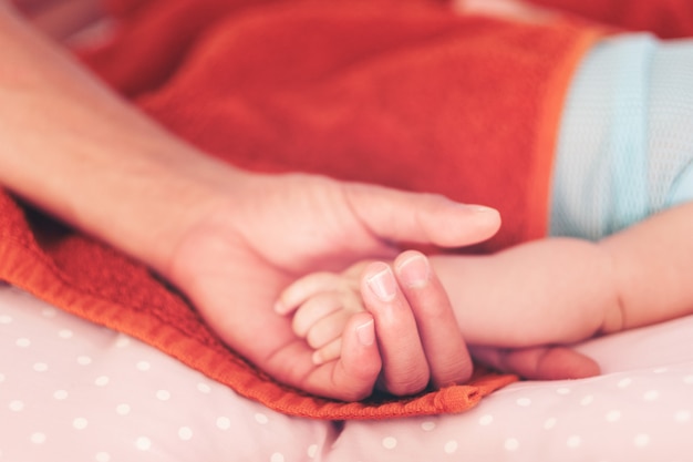 Père tenant la main du bébé nouveau-né.