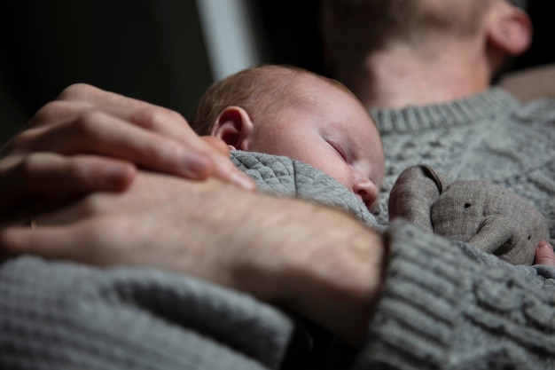 Un père tenant son bébé sur sa poitrine Liens familiaux Paternité