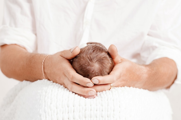 Père Tenant La Tête De Sa Fille Nouveau-née Dans Les Mains. Bébé Sur Les Mains à Papa.