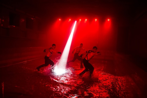 Performance sur l'eau d'un groupe de danse sur fond de lumière de club.