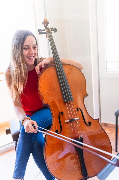 Photo performance soulful jeune violoncelliste embrassant le charme de la maison