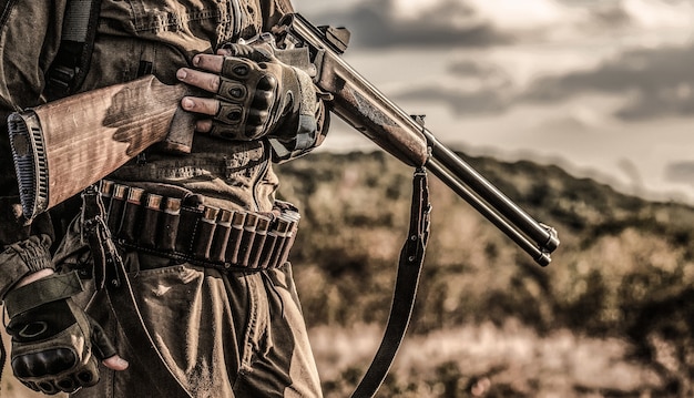 Période de chasse, saison d'automne. Homme avec une arme à feu. Chasseur avec un sac à dos et un fusil de chasse. Un chasseur avec un fusil de chasse et un formulaire de chasse pour chasser.