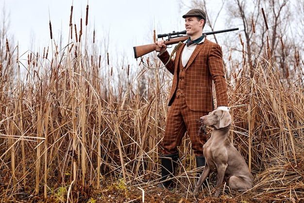 Photo période de chasse, saison d'automne ouverte. chasseur caucasien confiant avec chien et arme à feu