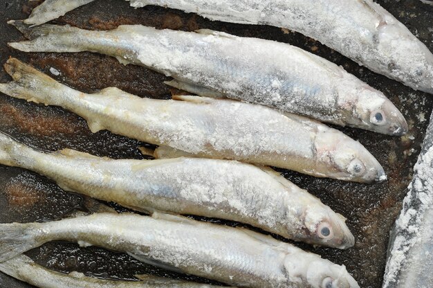 Éperlan de poisson en farine frit dans une poêle