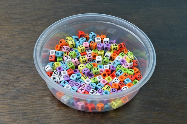 Perles alphabet coloré dans un bol en plastique