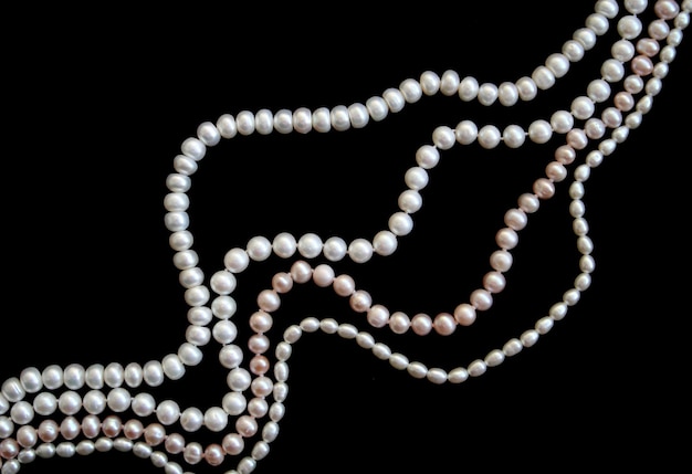Des perles blanches et roses sur la soie noire