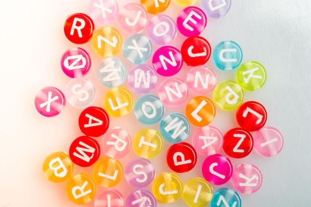 Perles de lettres alphabet multicolores placées au hasard