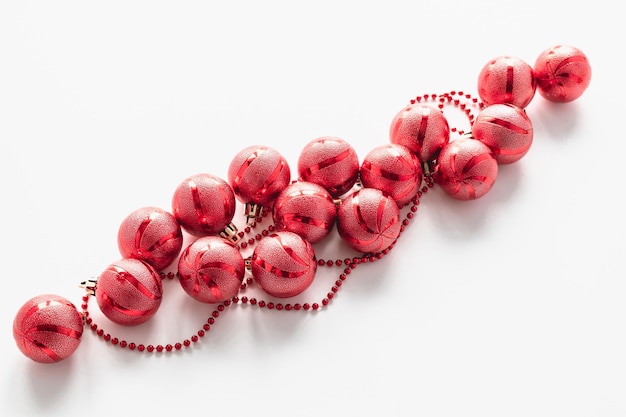 Perles de Noël et boules de Noël rouges sur fond blanc. Carte de Noël.