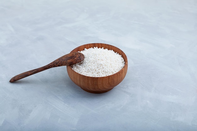 Perles de tapioca blanches dans un bol en bois avec cuillère en bois Boules de tapioca utilisées pour les boissons au thé à bulles boba