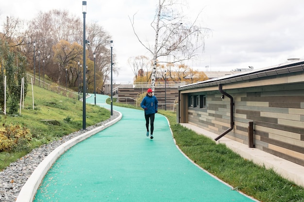 Perm, Russie - 19 octobre 2021 : homme faisant du jogging sur une piste de course tous temps dans un environnement urbain