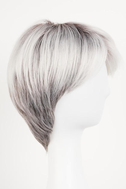 Perruque blonde argentée d'aspect naturel sur la tête de mannequin blanc Cheveux courts sur le porte-perruque en plastique isolé sur la vue latérale de fond blanc