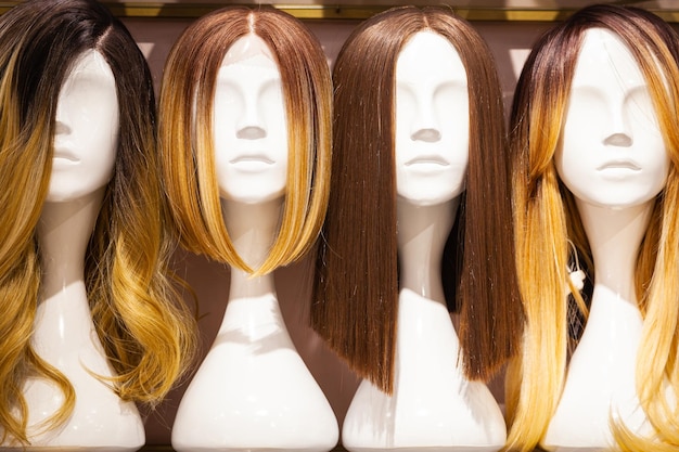 Perruques féminines posées sur la tête des mannequins