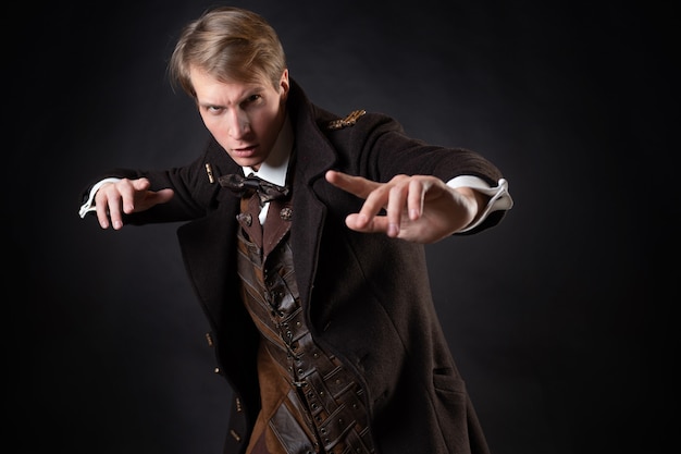 Personnage de l'histoire steampunk un jeune homme séduisant dans un long manteau élégant