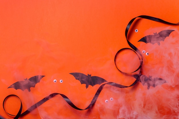 Personnages d'halloween noirs et accessoires sur une surface orange vif