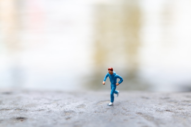 Personnages miniatures courant sur le rocher