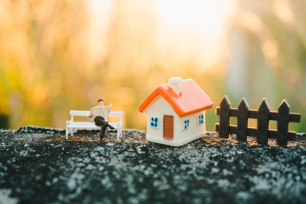 Personnages miniatures, homme lisant un journal à la maison