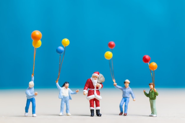 Personnages miniatures: Père Noël et enfants tenant un ballon