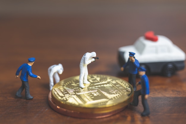 Personnages miniatures: police et détective devant le bitcoin Crypto-monnaie