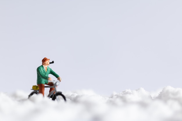 Personnages miniatures: voyageurs à vélo sur la neige